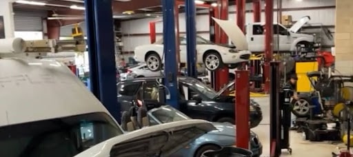 Save money with car maintenance in Groveland, Fl, with Griffis Automotive Clinic. A busy car repair shop filled with various vehicles awaiting maintenance and repairs on the workshop floor.