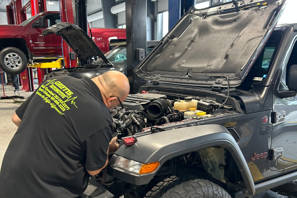 Engine Overheating Service, Engine Repair in Groveland FL at Griffis Automotive Clinic. Mechanic inspecting a vehicle engine at an auto repair shop