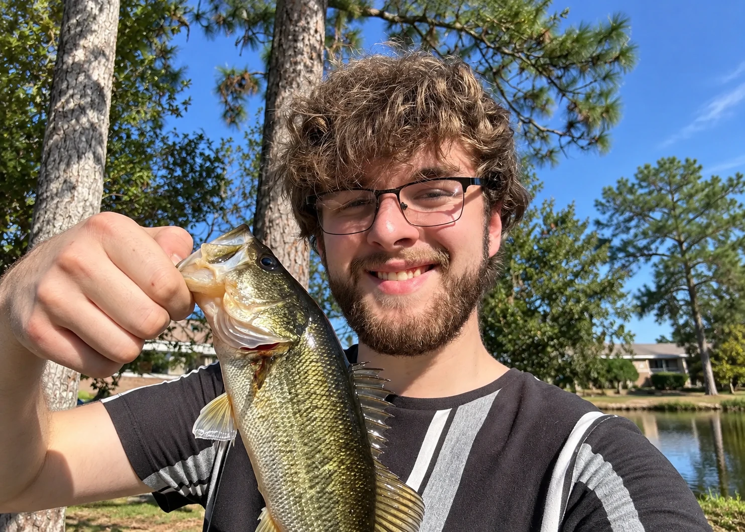 Griffis Automotive team member Andrew holding a fish outdoors